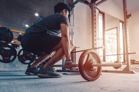 sportsman lifting a barbell at the gym. Fitness, gym, workout and lifte style concept.の写真素材