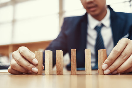 Male hand stacking wooden blocks. Business development and growth concept