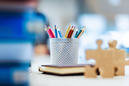 Thick wood jigsaw on the table near book, pencil case and blackboard at library. Education learning and grow up  concept.の写真素材