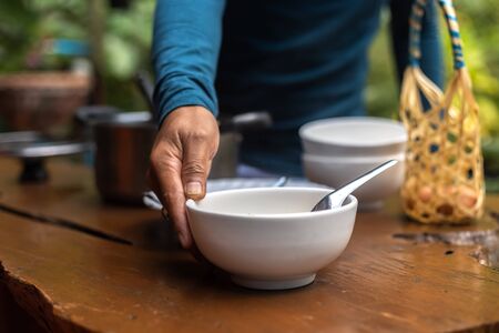 A man placing a rice soup on the table.の写真素材