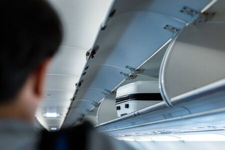 luggage on the top shelf on airplaneの写真素材