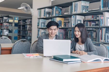 High school or college students studying and reading together in library. Student use laptop at library.の写真素材