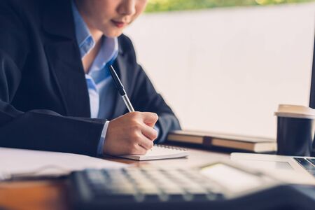 businesswomen calculating, writing and checking for making report financial. の写真素材