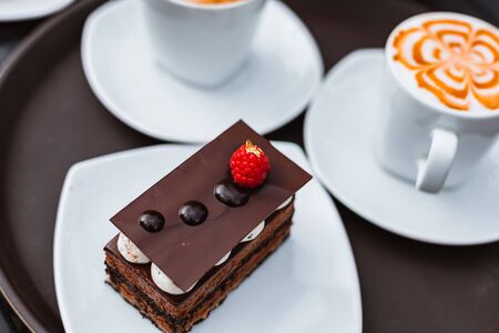 Slice of chocolate cake, Cutlery steak basket and donot with coffee on the table. の写真素材