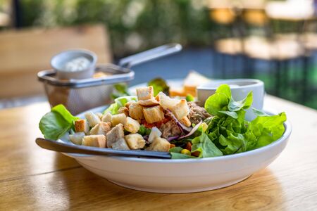 salad with tuna, salad dressing in bowl on the table.の写真素材