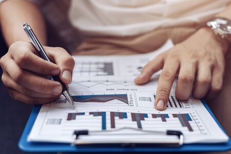 Businessman hold pen and working calculate data. document graph chart and report marketing. Business office concept.の写真素材