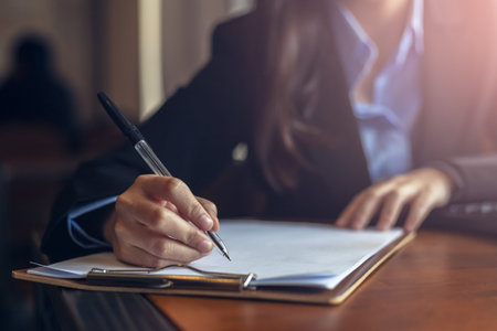 businesswomen calculating, writing and checking for making report financial. の写真素材