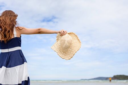 Woman barefoot walking on summer along wave of sea water and sand on the beach. の写真素材
