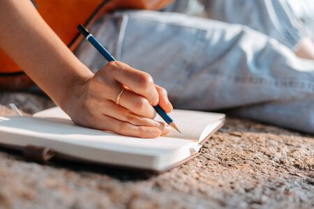 songwriter create and writing notes,lyrics in the book on stone at parks.の写真素材
