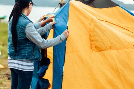 A group of friends traveling and camping near lake and mountain back.の写真素材