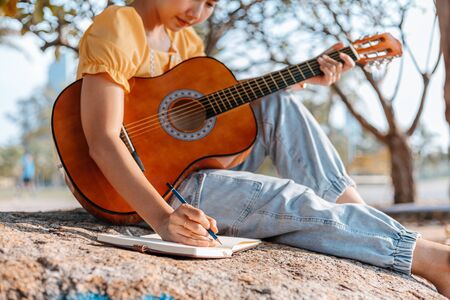 songwriter create and writing notes,lyrics in the book on stone at parks.の写真素材