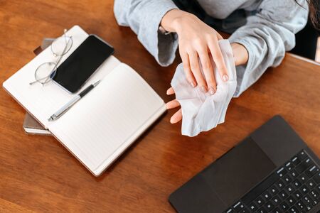 Woman cleaning her hands with a tissue. woman working from home.の写真素材