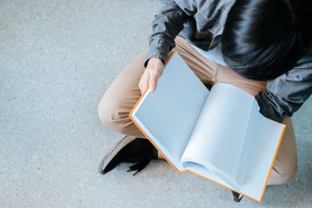 Student college opening and reading a book at library.