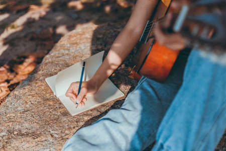 songwriter create and writing notes,lyrics in the book on stone at parks.の写真素材