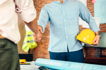 Architect and businessman handshake after finish an agreement in the office at  site construction.