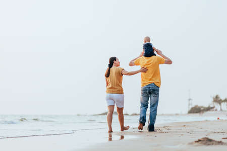 Happy family on the beach.  Father, mother and baby having fun on summer vacation. Holiday travel conceptの写真素材
