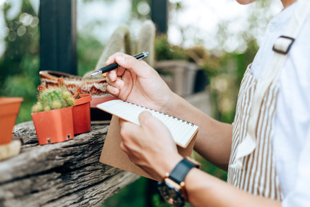 man check cactus and writing note in book. people enjoy hobby with garden cactus.