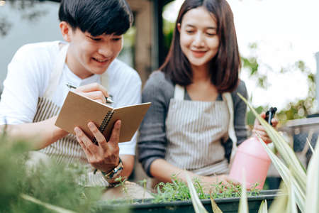 Young couple relax in the garden. They care plant and flower.の写真素材