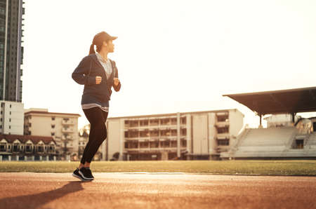 Runner jogging in sun light. Female fitness model training in the city. Healthy and lifestyle conceptの写真素材