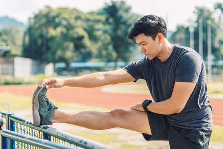 Young man stretching muscles before and after training. Fitness and sport concept.の写真素材