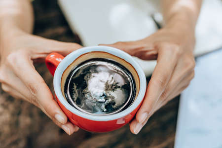 Hand hold cup of coffee between working. Drink of coffeeの写真素材