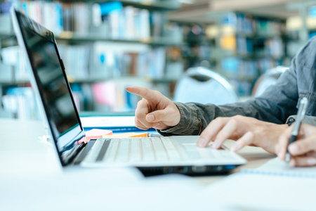 Students studying in the library with laptop at the university. Education concept.