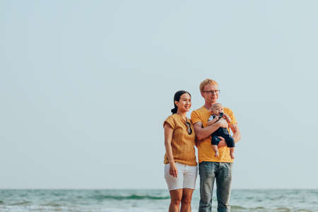 Happy family on the beach.  Father, mother and baby having fun on summer vacation. Holiday travel conceptの写真素材
