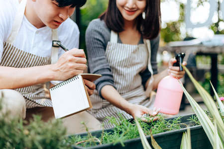 Young couple relax in the garden. They care plant and flower.の写真素材