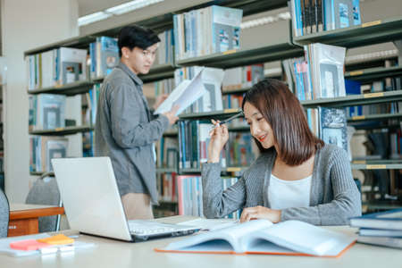 Students studying in the library with laptop at the university. Education concept.の写真素材