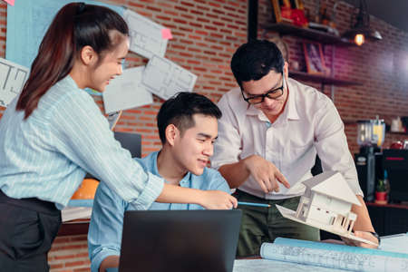 Businessman and architech meeting for planing and checking house design and house model and secretary takes notes meeting.の写真素材