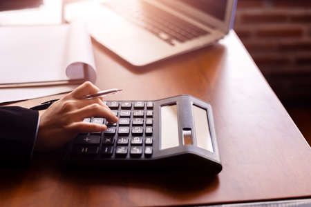 Business women  working with calculator and  business document on office table in office. finance accounting concept.の写真素材