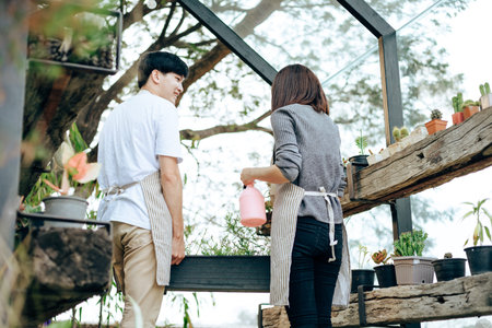 Young couple relax in the garden. They care plant and flower.