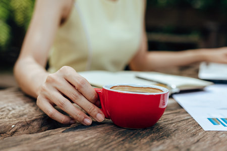 Hand hold cup of coffee between working. Drink of coffee