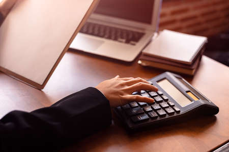 Business women  working with calculator and  business document on office table in office. finance accounting concept.の写真素材