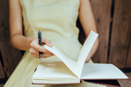 Women writing note book on the table.
