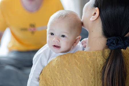 happy mother, father with baby playing together at home. Mother hug baby.の写真素材