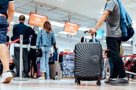people waiting for check in at airport. A man and luggage at the airport terminal.の写真素材