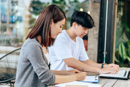 High school or college students  group catching up workbook and learning tutoring on desk and reading, doing homework, lesson practice preparing exam.
studying and reading together in library education concepts. Education concept.の写真素材