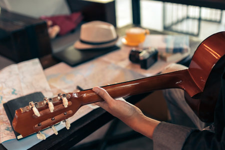 man's hands playing acoustic guitar between planing travel.の写真素材
