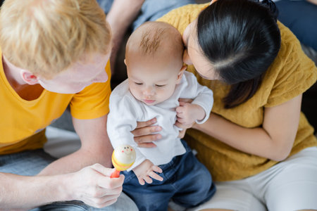 happy mother, father with baby playing together at home. Family, parent and baby concept.