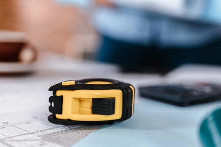 Measure tape, calculate,  safety helmet, book on house blue print. Engineering, plaining, drafting  tool and equipment concept.の写真素材