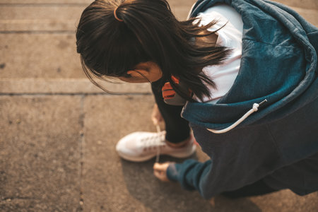 Woman tying shoe laces. Woman fitness runner get ready for jogging on way in the city.の写真素材