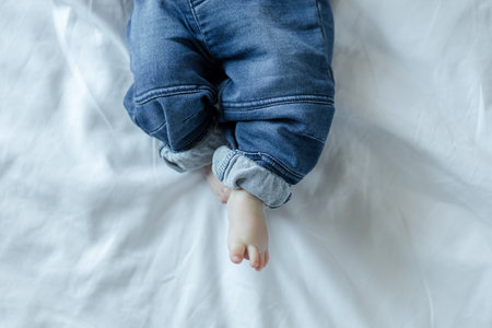 Baby feet on white bed backgroundの写真素材