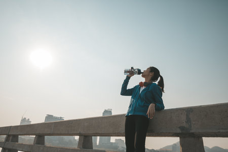 woman athlete thirsty takes a break. she drinking water after running.の写真素材