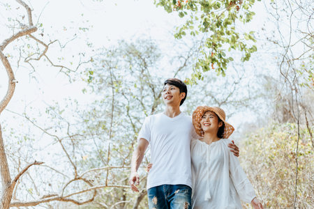 Couple of lovers hug and walking on wood bridge in the forest.  Newlywed couple on a romantic...