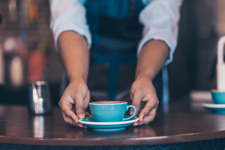 Barista serving a coffee to customer at the coffee shop.の写真素材