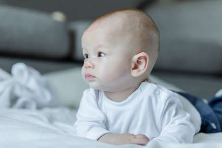 Cute baby on white bed. Baby, newborn concept.の写真素材