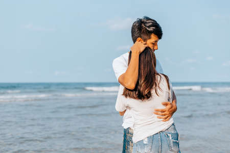 romantic couple hug together on the beach at summer. Honeymoon, travel, holiday, summer concept.の写真素材