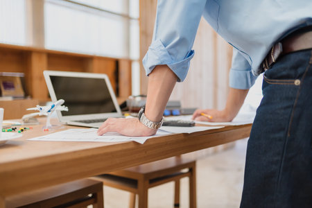 Businessman stand up and reading paper graph and checking document data calculator for calculate budget accountancy. finance and accounting concept.の写真素材