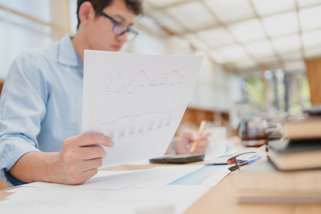 Businessman hold paper graph and checking document data calculator for calculate budget accountancy....